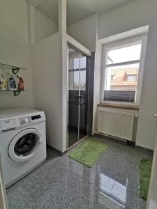 a laundry room with a washing machine and a window at Schmetterling Zimmer in Bad Lausick