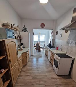a kitchen with white appliances and a wooden floor at Schmetterling Zimmer in Bad Lausick