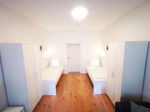 Zimmer mit weißen Kleiderschränken und Holzböden in der Unterkunft Quartier Langenstrich in Neunkirchen