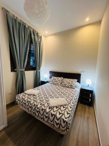 ein Schlafzimmer mit einem Bett, zwei Lampen und einem Fenster in der Unterkunft HOSPEDAJE CORREDOR DE HENARES in Torrejón de Ardoz