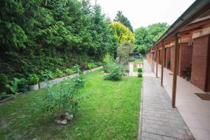 a garden with a lawn with plants and a building at Duna-Party Pansion in Budapest