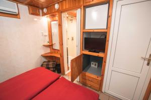 1 dormitorio con cama roja y TV. en Duna-Party Pansion, en Budapest