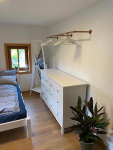 een slaapkamer met een bed en een dressoir en een plant bij Ferienwohnung Lichterhof in Sebnitz