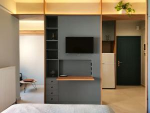 a bedroom with a refrigerator and a tv on a wall at Lydia's Rainbow in Preveza