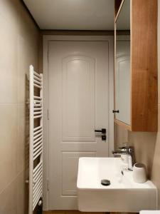 a bathroom with a white sink and a door at Lydia's Rainbow in Preveza