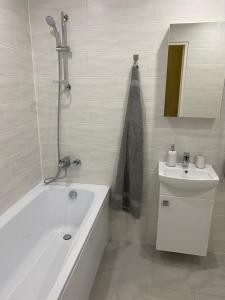 Baño blanco con bañera y lavamanos en Narva mnt 23```, en Jõhvi