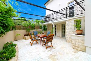 un patio con tavolo e sedie in legno di House Rakalj 2164 a Rakalj