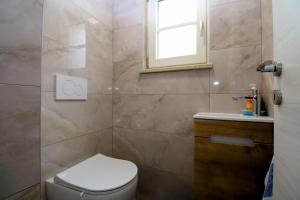 un bagno con un water, una finestra e un lavandino di House Rakalj 2164 a Rakalj Altre 16 foto
