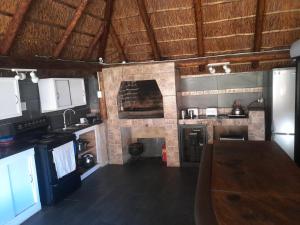 a kitchen with a wooden table and a stone wall at 1322 Backpackers International in Pretoria