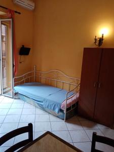 a bedroom with a bed and a cabinet and a table at Lina House in Giardini Naxos