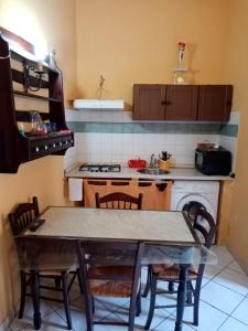 a kitchen with a table and chairs and a stove at Lina House in Giardini Naxos