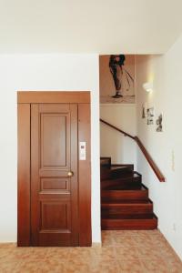 a hallway with a wooden door and stairs at Βίλλα Φανούλα Villa Fanoula in Chorto