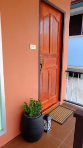 una gran puerta de madera con una planta delante en The Backyard Homestay, en Pak Chong