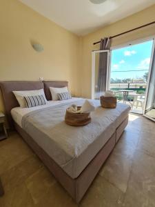 a bedroom with a large bed with a large window at Fontana Apartments in Moraitika