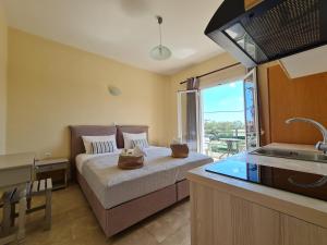 ein Schlafzimmer mit einem Bett und eine Küche mit einem Waschbecken in der Unterkunft Fontana Apartments in Moraḯtika