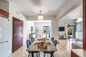 uma cozinha e sala de jantar com mesa e cadeiras em Maison d'Olivier em Gerani