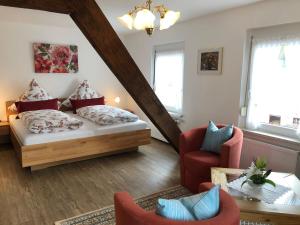ein Wohnzimmer mit einem Bett und einem Stuhl in der Unterkunft Gästehaus Mack in Trittenheim