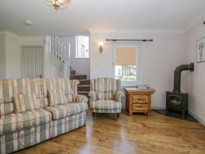 a living room with a couch and a chair and a wood stove at Viewpoint in Kendal