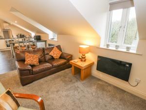 sala de estar con sofá y TV en Woodlands, en Keighley