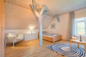 um quarto com uma cama e uma árvore no tecto em "Gästehaus Summersby" - Natururlaub mit exklusivem Landhausflair em Westfehmarn