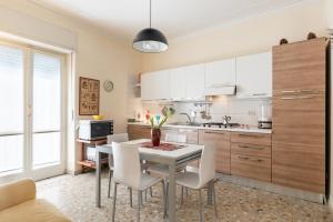 cocina con mesa blanca y sillas blancas en Stadio & Villa Bellini Big APT with Terrace, en Catania