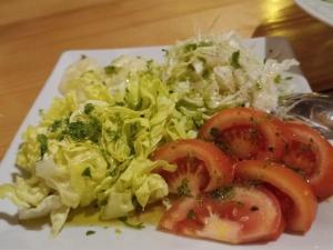 a plate of salad and tomatoes on a table at House ThoNi in Gornji Štoj
