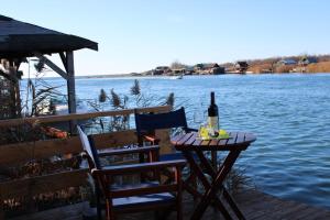 a table with a bottle of wine and a chair on a dock at House ThoNi in Gornji Štoj