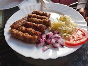 a plate of food with chicken skewers and vegetables at House ThoNi in Gornji Štoj