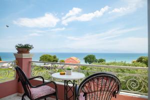 balcón con mesa, sillas y vistas al océano en Villa Bambas Resort, en Astrakeri