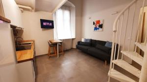 ein Wohnzimmer mit einem schwarzen Sofa und einem Fenster in der Unterkunft ALmare - Nice & Easy in Livorno