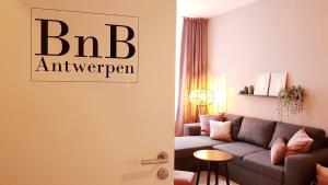 a living room with a couch and a table at BnB Antwerpen - CHARMANT in Antwerp