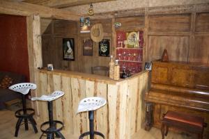 a bar with stools and a piano in a room at Chez de Vergne in Chanterelle