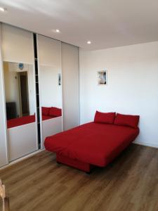 een slaapkamer met een rood bed in een kamer bij Réter in Aytré