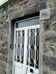 a white door with a sign on a stone building at Casa Dos Mosteiros in Mosteiros