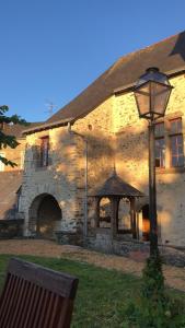 um edifício de pedra com uma luz de rua em frente em Le logis du Vassal em Laval