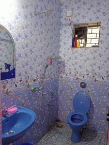 a bathroom with a blue toilet and a sink at Shanaya Holiday Apartment in Benaulim