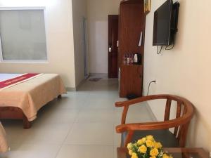 Pokój z łóżkiem, krzesłem i telewizorem w obiekcie Khách sạn NHẬT MINH Cửa Lò w mieście Cửa Lô