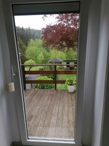 a door to a balcony with a view of a yard at Ferienwohnung Waldblick mit Balkon in Sebnitz