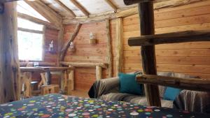 a log cabin with a bed in a room at Colline de Boutiès in La Barthe