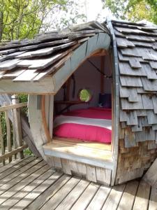 a bed in a doghouse on a deck at Colline de Boutiès in La Barthe