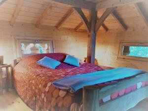 a bedroom with a bed in a wooden cabin at Colline de Boutiès in La Barthe