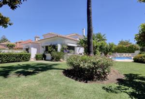 a house with a palm tree and a yard at El Cafetal de Veronica in Marbella