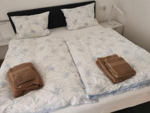 a bed with two towels sitting on top of it at Ferienwohnung Northeim City in Northeim