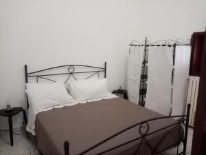 una camera da letto con letto in metallo e cuscini bianchi di Masseria Chianca - Le rose a Mottola