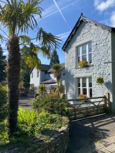 a house with a palm tree in front of it at Rooms at The Usk in Talybont