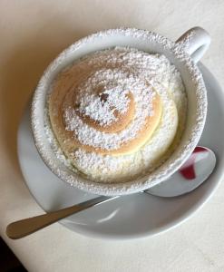 une tasse de café avec du sucre en poudre sur une assiette dans l'établissement See-Hotel Post am Attersee, à Weissenbach am Attersee