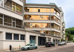budynek z samochodami zaparkowanymi przed nim w obiekcie Le Loft Horloger avec parking w Besançon