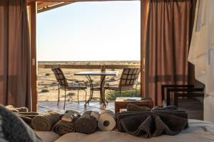 a bedroom with a bed with a view of the beach at Teufelskrallen Lodge in Kalkrand