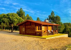 a small wooden cabin on a field of sand at Montum Farm Living in Melides