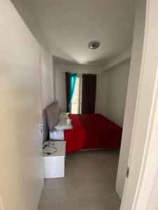カステルサルドにあるAppartamento Smeraldoの赤いベッドと窓が備わる小さな客室です。